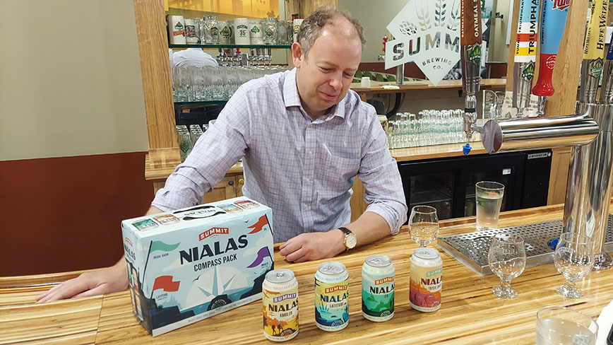 Damian McConn with Nialas NA beer 12-pack and cans at Summit Brewing Company