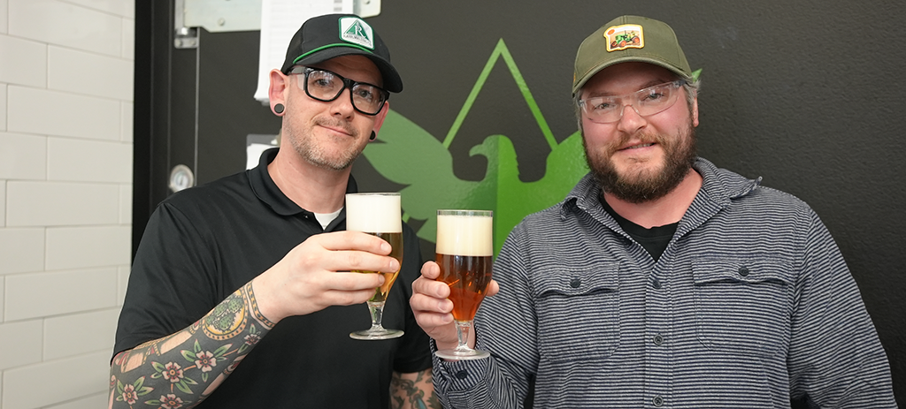Image of two brewers Jake Thompson and Sean Tynan toasting glasses of beer.