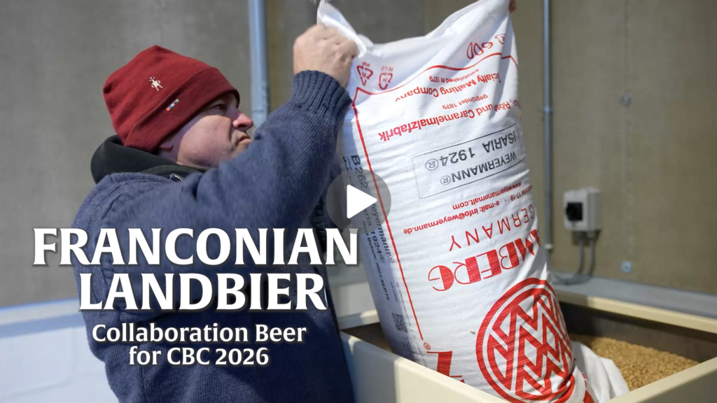 Gretz Brewing pours bag of malt into mill; play button superimposed for video
